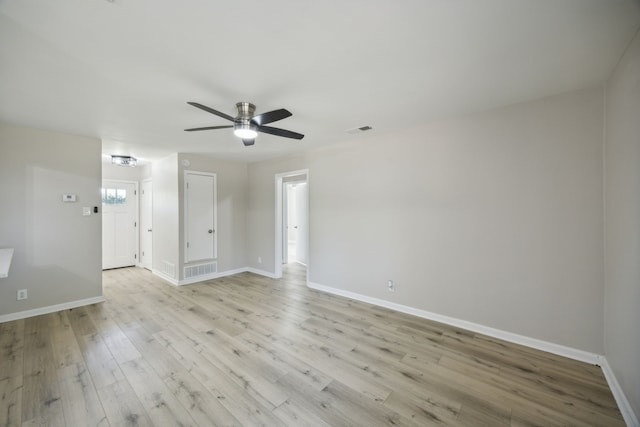 spare room featuring baseboards, light wood-style flooring, visible vents, and a ceiling fan