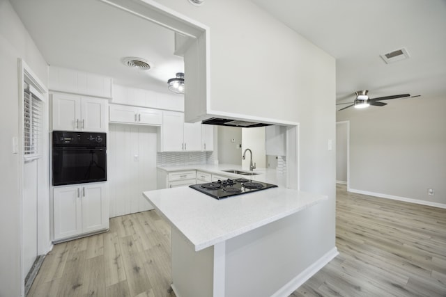 kitchen featuring white cabinetry, visible vents, black appliances, and a sink