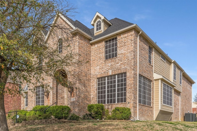 view of property exterior featuring cooling unit and brick siding