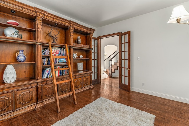 living area with baseboards, arched walkways, dark wood-type flooring, and french doors
