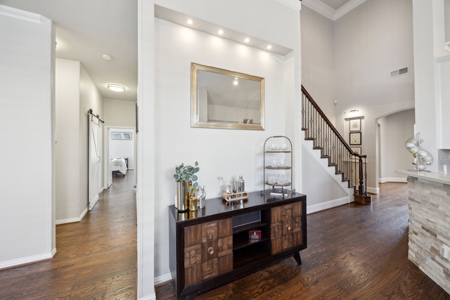 2937 Lago Vista Ln, Rockwall, TX 75032 - hallway with wood finished floors, stairway, arched walkways, a barn door, and crown molding