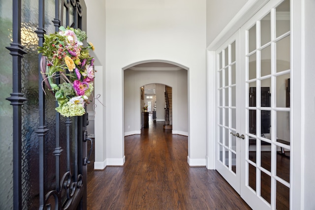 2937 Lago Vista Ln, Rockwall, TX 75032 - entryway featuring dark wood-style flooring, arched walkways, french doors, baseboards, and a towering ceiling
