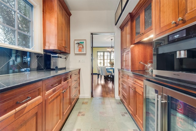 6722 Lakewood Blvd, Dallas, TX 75214 - kitchen featuring wine cooler, tasteful backsplash, brown cabinets, glass insert cabinets, and stone finish floor