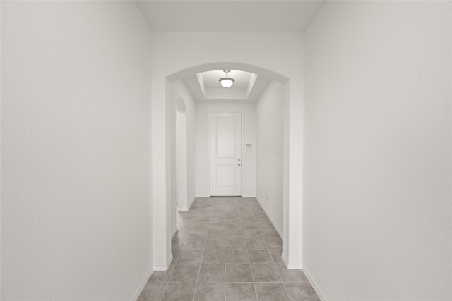 919 Madeline Ln, Cleburne, TX 76033 - hallway with arched walkways, a raised ceiling, light tile patterned floors, and baseboards