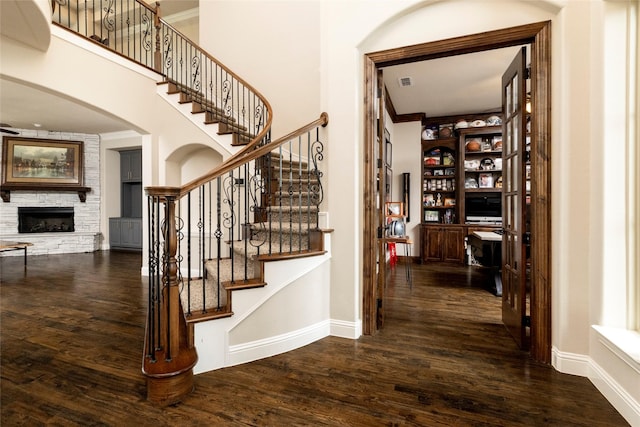 1413 Artesia Ln, Mclendon Chisholm, TX 75032 - stairway with crown molding, wood finished floors, a fireplace, baseboards, and arched walkways