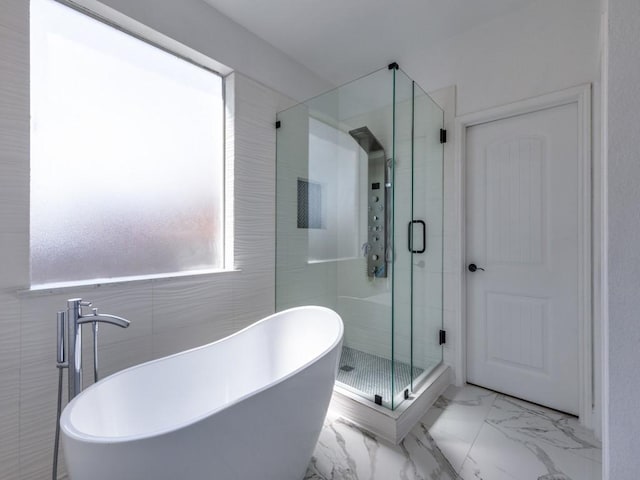 bathroom featuring a freestanding tub, a shower stall, and marble finish floor