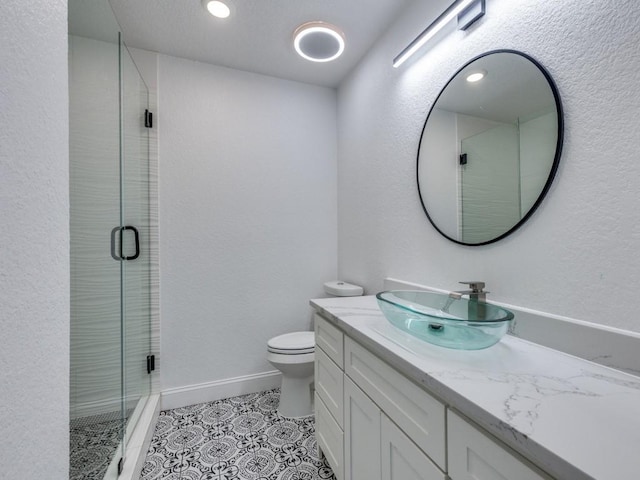 bathroom featuring vanity, tile patterned flooring, a stall shower, and toilet