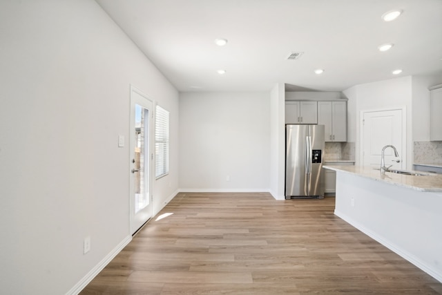 3910 Walmer Way, Princeton, TX 75071 - kitchen with stainless steel fridge with ice dispenser, a sink, recessed lighting, light wood finished floors, and tasteful backsplash