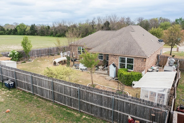 412 Lake St, Red Oak, TX 75154 - back of house with a fenced backyard, brick siding, and roof with shingles