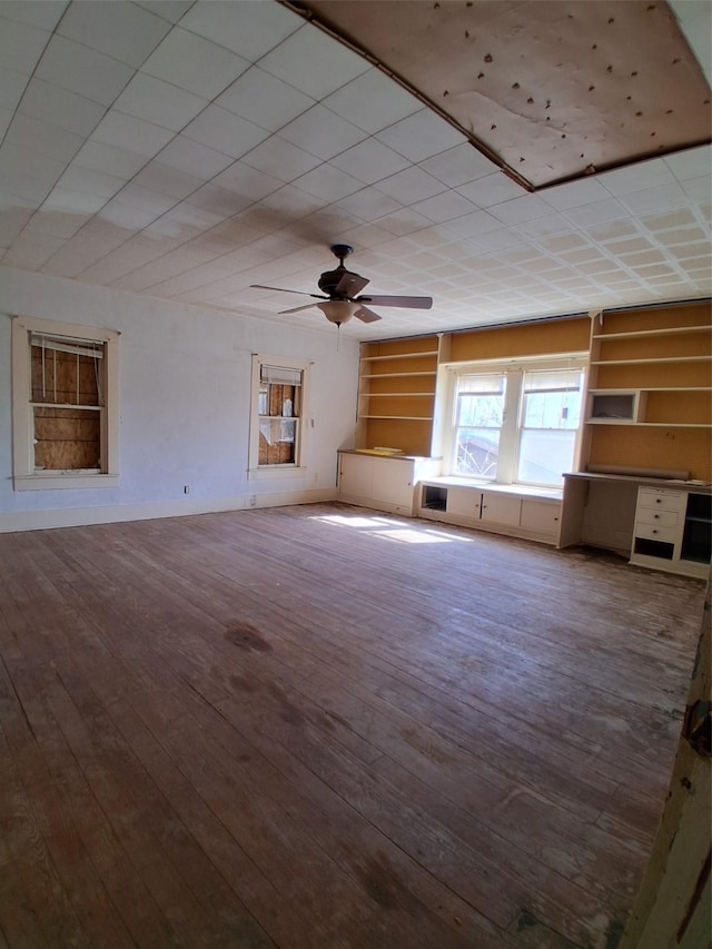 208 E 4th St, Coleman, TX 76834 - unfurnished living room featuring ceiling fan, built in features, and hardwood / wood-style flooring