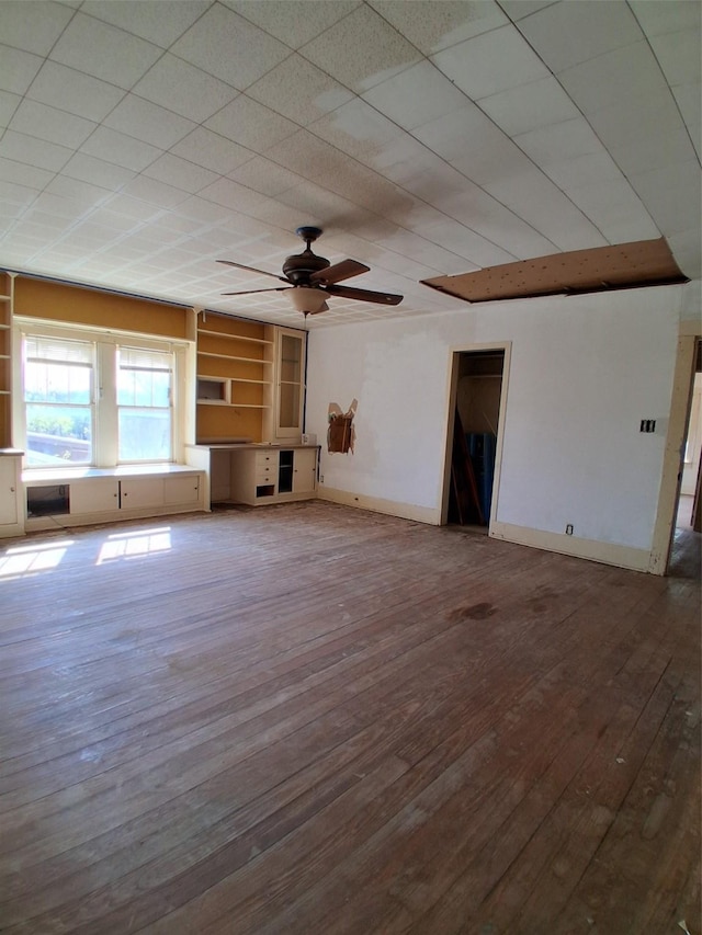 208 E 4th St, Coleman, TX 76834 - unfurnished living room with a ceiling fan, baseboards, and wood-type flooring
