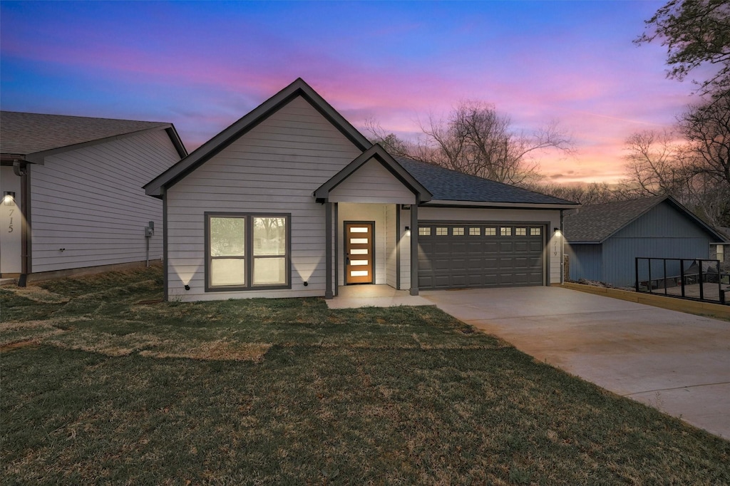 719 E Hanna St, Denison, TX 75021 - view of front facade with driveway, an attached garage, and a lawn