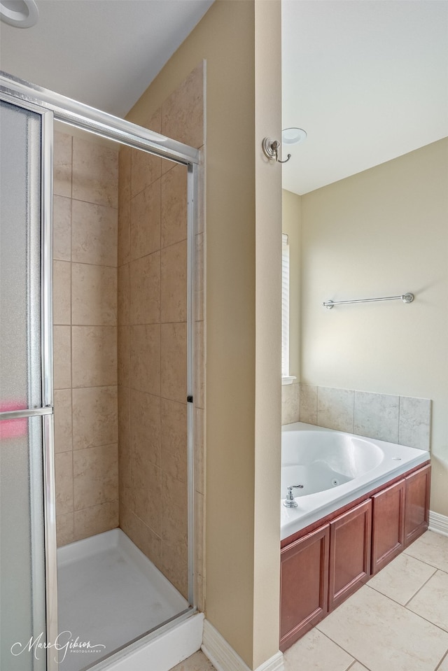 full bath with tile patterned floors, a bath, and a stall shower