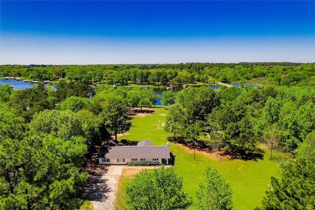 birds eye view of property featuring a water view and a wooded view