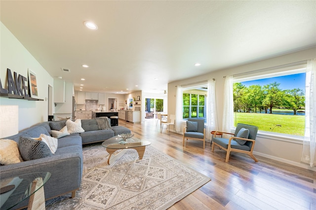 living room with visible vents, light wood-style flooring, recessed lighting, and baseboards