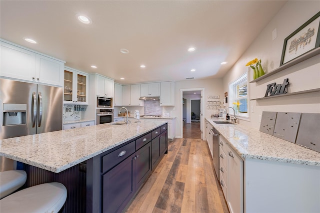 kitchen with white cabinetry, appliances with stainless steel finishes, a sink, and open shelves