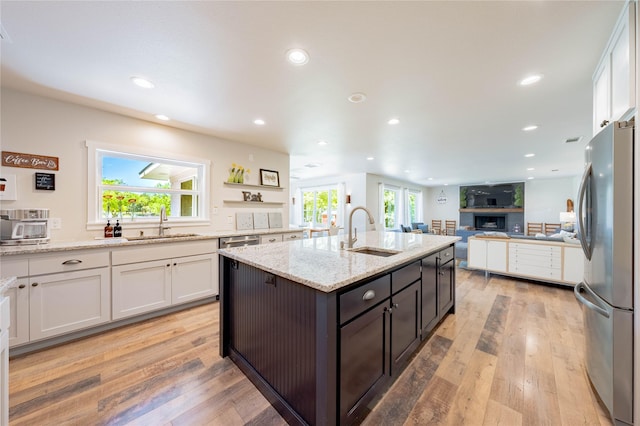 kitchen featuring freestanding refrigerator, a sink, and white cabinetry