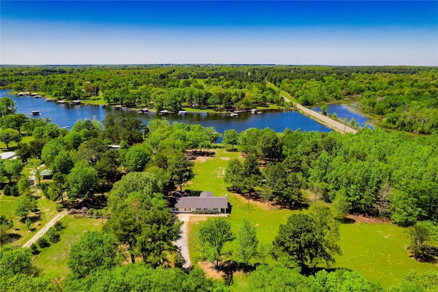 aerial view featuring a wooded view and a water view