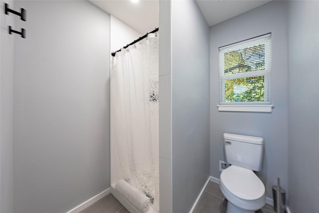 full bath with tile patterned floors, toilet, baseboards, and a stall shower