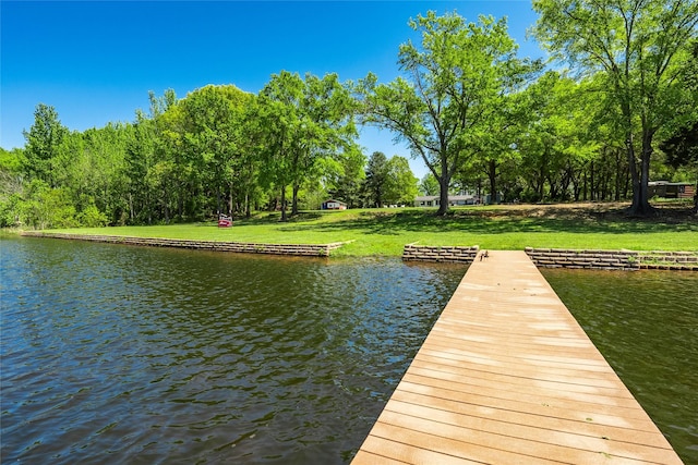 view of dock featuring a lawn and a water view