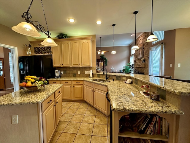 2610 Jakes Ct, Midlothian, TX 76065 - kitchen featuring black fridge, light brown cabinetry, a sink, backsplash, and light stone counters