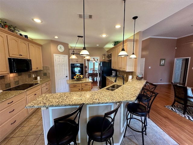 2610 Jakes Ct, Midlothian, TX 76065 - kitchen featuring a sink, black appliances, light brown cabinetry, a breakfast bar, and ornamental molding