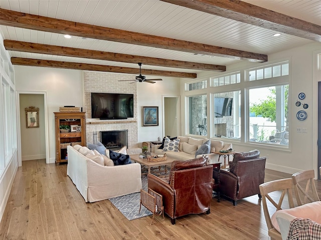 712 Camp Cypress Trl, Winnsboro, TX 75494 - living area with baseboards, light wood-type flooring, ceiling fan, and a brick fireplace