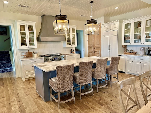 712 Camp Cypress Trl, Winnsboro, TX 75494 - kitchen featuring custom range hood, stove, tasteful backsplash, and light wood finished floors