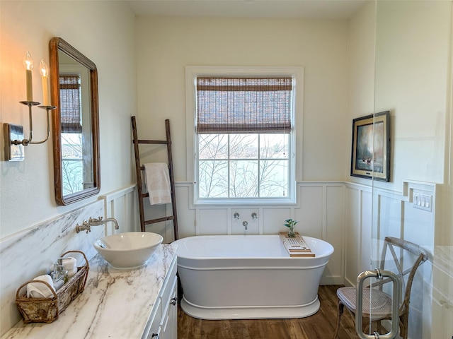 712 Camp Cypress Trl, Winnsboro, TX 75494 - full bathroom with wainscoting, wood finished floors, a freestanding bath, and vanity