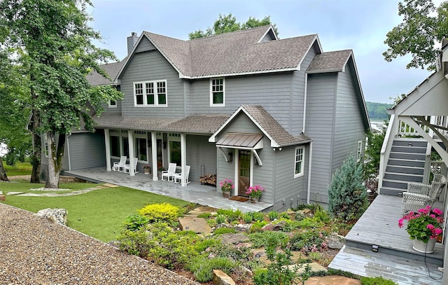 712 Camp Cypress Trl, Winnsboro, TX 75494 - back of house featuring a chimney, stairway, roof with shingles, a lawn, and a patio area