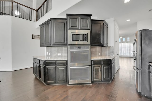 4024 Alpine Rose Ct, Roanoke, TX 76262 - kitchen featuring stainless steel appliances, decorative backsplash, light stone counters, dark wood-style flooring, and recessed lighting