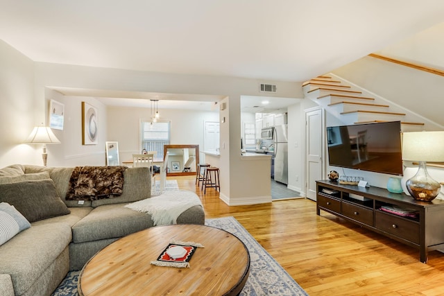 6345 Bordeaux Ave, Dallas, TX 75209 - living area with baseboards, stairs, visible vents, and light wood finished floors