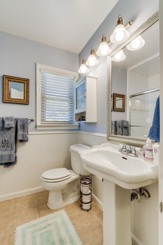 6345 Bordeaux Ave, Dallas, TX 75209 - bathroom featuring a wainscoted wall, tile patterned floors, toilet, and a shower with shower door