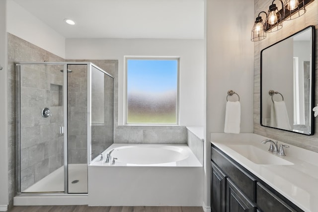 bathroom with a bath, a shower stall, and vanity