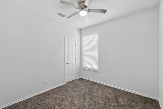 unfurnished room featuring dark carpet, baseboards, a ceiling fan, and visible vents