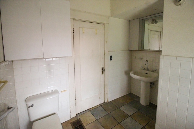 418 Merchant St, Abilene, TX 79603 - bathroom featuring visible vents, toilet, and tile walls
