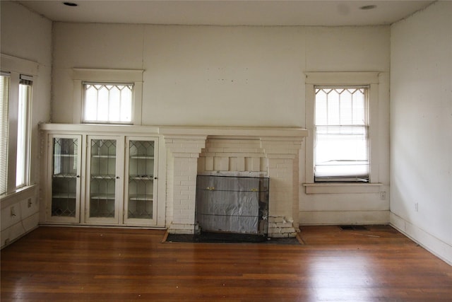 418 Merchant St, Abilene, TX 79603 - unfurnished living room with visible vents, wood finished floors, and a fireplace