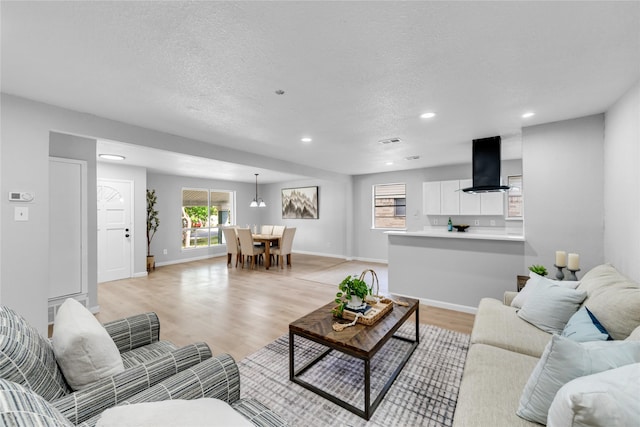 2416 Glacier St, Irving, TX 75062 - living area featuring recessed lighting, light wood-style flooring, a textured ceiling, and baseboards