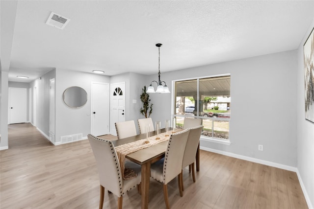2416 Glacier St, Irving, TX 75062 - dining area featuring baseboards, light wood-style floors, and a chandelier