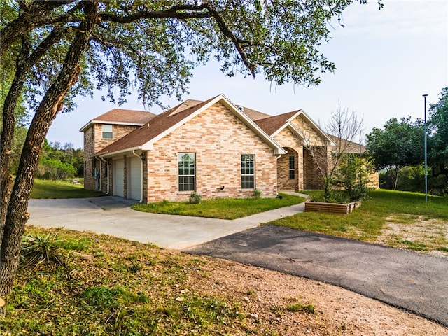2800 Lomas Rodando Calzada, Kempner, TX 76539 - traditional-style house featuring driveway, brick siding, a garage, a front lawn, and a shingled roof