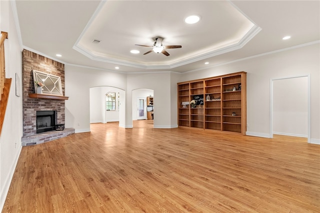 2800 Lomas Rodando Calzada, Kempner, TX 76539 - unfurnished living room featuring arched walkways, ceiling fan, a tray ceiling, light wood finished floors, and recessed lighting