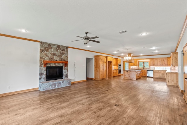 unfurnished living room featuring a fireplace, visible vents, light wood-style floors, ceiling fan, and ornamental molding