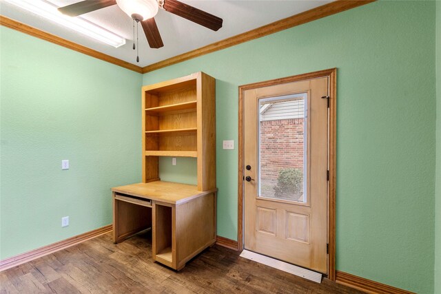 unfurnished office with baseboards, ornamental molding, a ceiling fan, and dark wood finished floors
