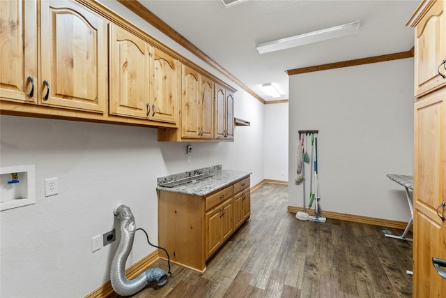 washroom featuring dark wood finished floors, hookup for an electric dryer, baseboards, cabinet space, and ornamental molding