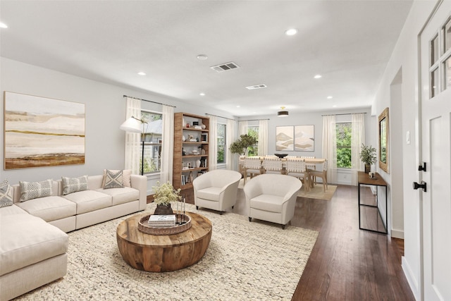 living room with dark wood-type flooring, visible vents, recessed lighting, and baseboards