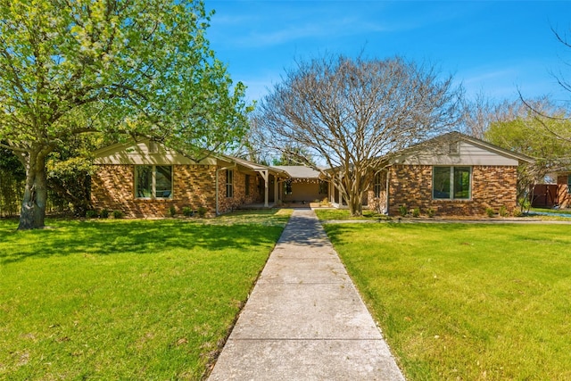 ranch-style house featuring brick siding and a front yard