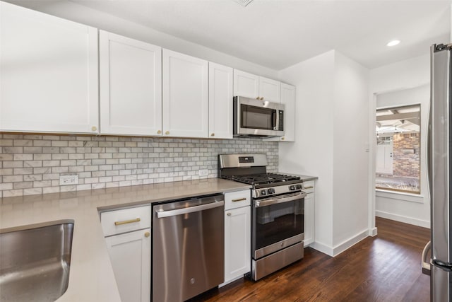 kitchen featuring decorative backsplash, baseboards, white cabinets, appliances with stainless steel finishes, and dark wood finished floors