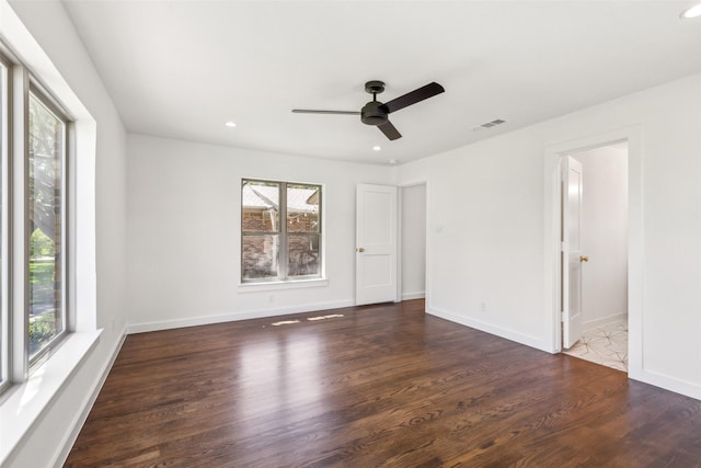 unfurnished room with a ceiling fan, visible vents, wood finished floors, and a healthy amount of sunlight