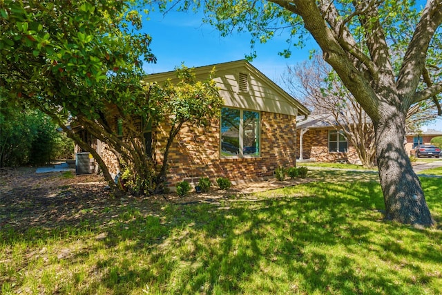 view of front of house with central AC and a front lawn