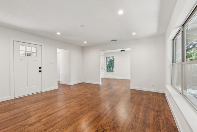 interior space with baseboards, visible vents, dark wood-style flooring, and recessed lighting